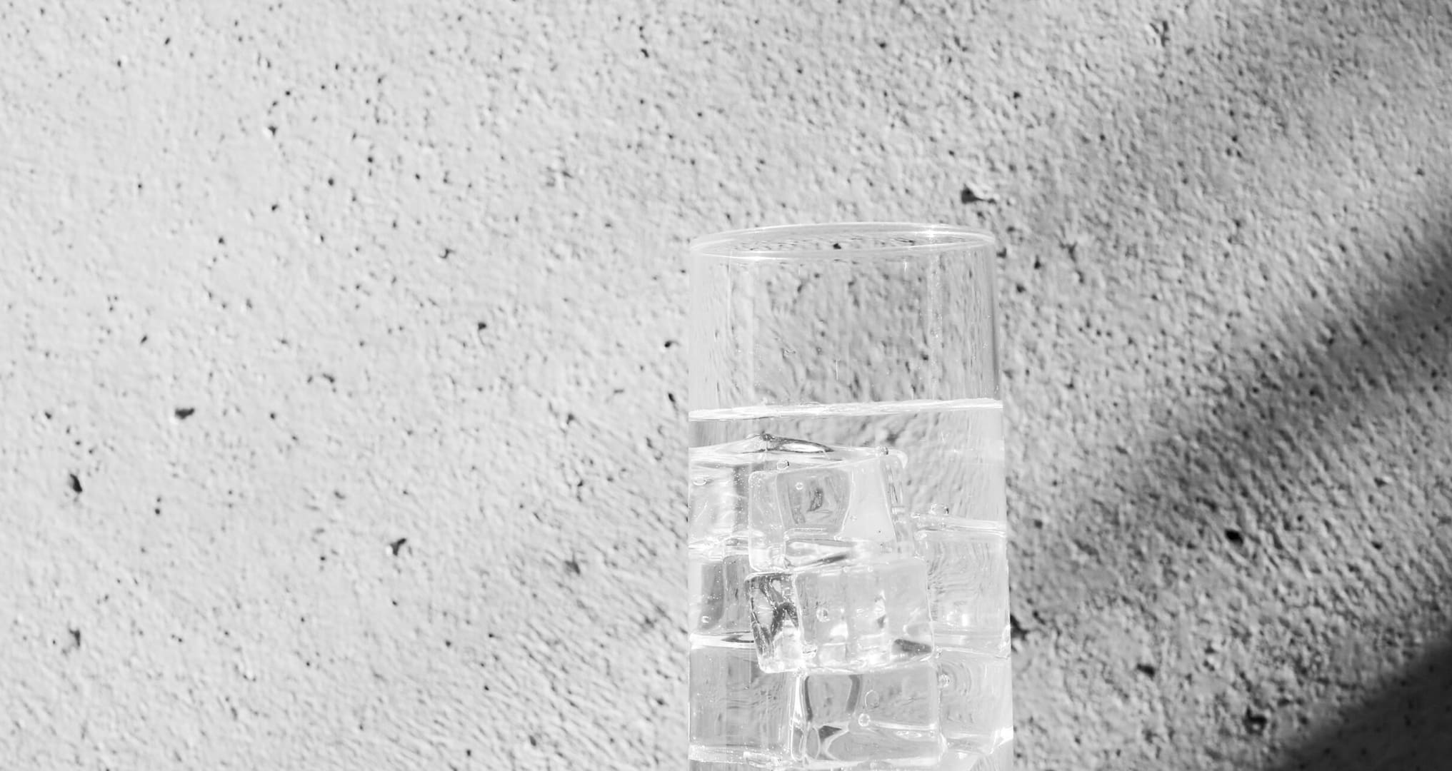 glass of ice water against wall