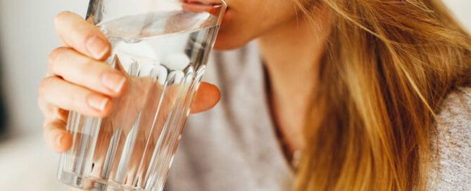 woman drinking water from glass