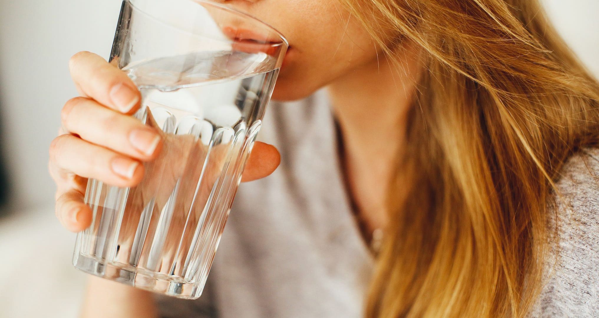 woman drinking water from glass