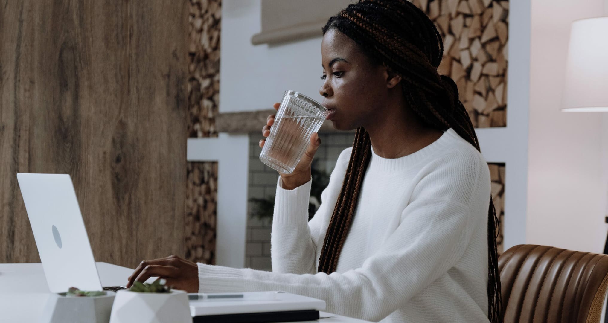 woman working at desk drinking fresh water