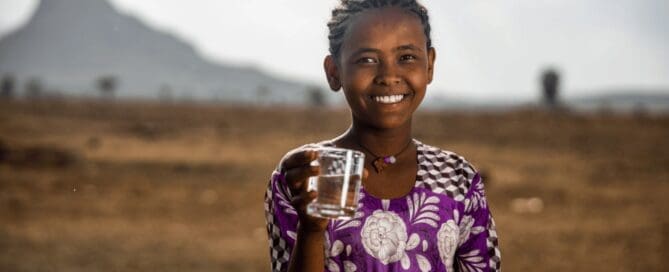 kid holding a glass of clean drinking water