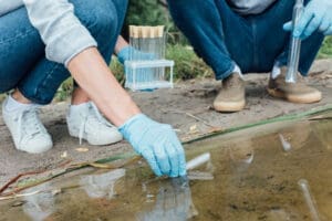 scientists taking a sample of water for regulations study