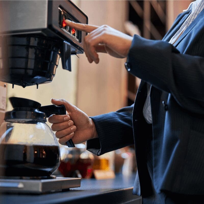 young woman getting coffee from coffee machine